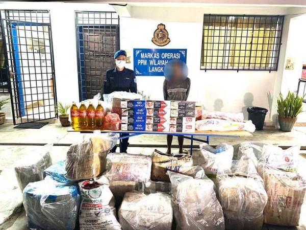 Suspek bersama barang-barang yang cuba diseludup keluar dari Malaysia di perairan Tanjung Dendang, Langkawi, semalam.- Foto PPM Langkawi
