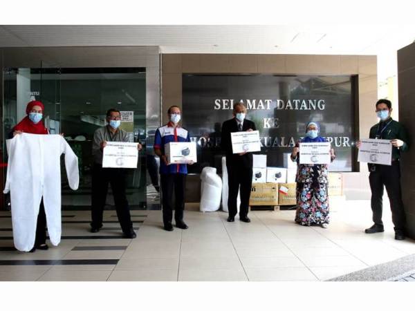 Ahmad Dasuki (tiga dari kiri) menyerahkan sumbangan PAPR dan PPE daripada PTPTN kepada Dr Heric Corray (tiga dari kanan) di Hospital Kuala Lumpur semalam.