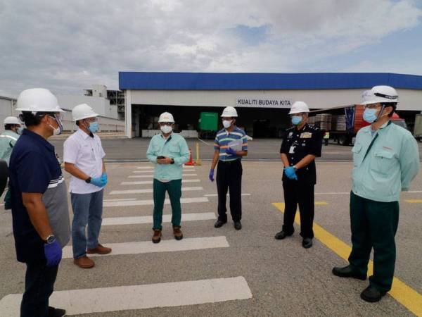 Sallehuddin (dua dari kiri) mendengar taklimat mengenai pematuhan SOP sewaktu mengadakan tinjauan di Kilang Polyplastics di Gebeng hari ini.