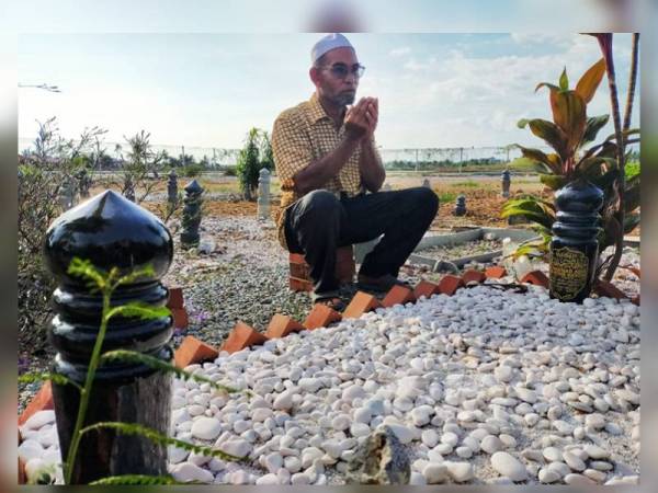 Bakri membacakan doa di pusara Muhammad Adib di Tanah Perkuburan Masjid As Saadah di sini semalam