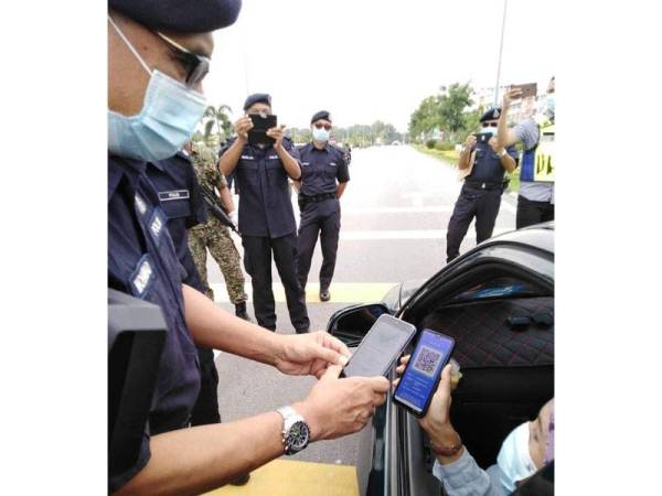 Mohammad memeriksa permohonan rentas negeri melalui Aps Gerak Malaysia pagi tadi. - Foto Polis NS