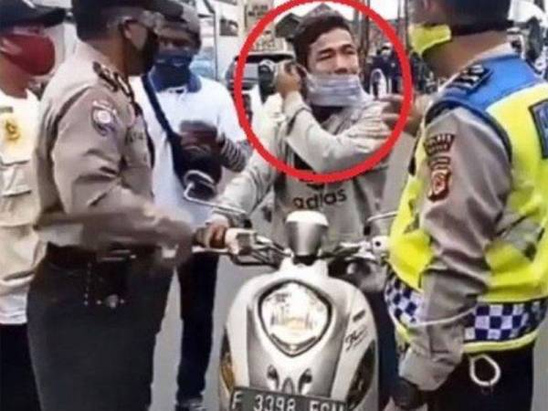 Lelaki yang ditegur pihak polis kerana memakai topeng muka tidak sempurna. - Foto Tribun News