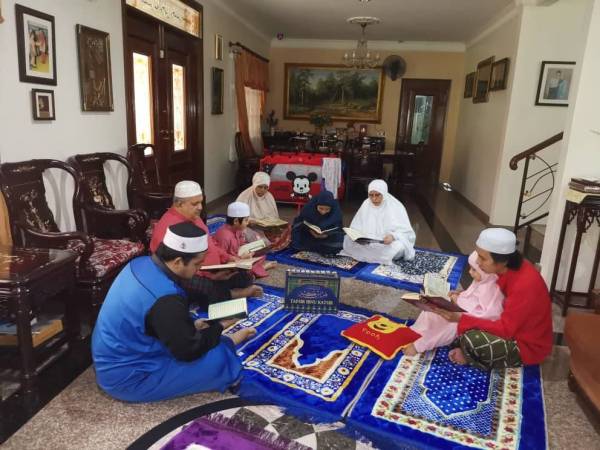 Ma'amor (dua dari kiri) bersama keluarga bertadarus bersama selepas solat.