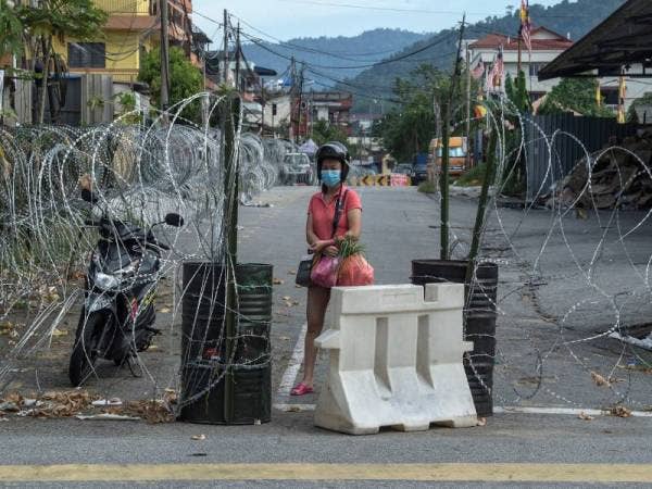 Kelihatan penghuni di kawasan Perintah Kawalan Pergerakan Diperketatkan (PKPD) Selayang Baru berdiri di hadapan kawat duri ketika tinjauan dilakukan semalam. - Foto Bernama