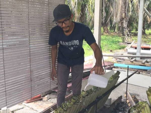 Imarul Safex mengisis santan ke dalam lemang jagung yang sedia untuk dibakar.