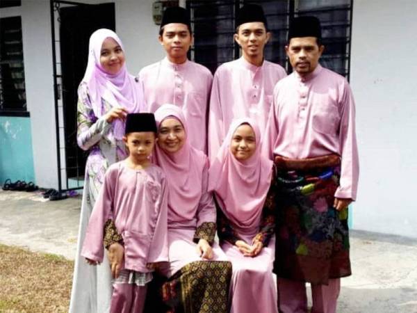 Adnan (berdiri, kanan) bersama isteri dan lima anak mereka.