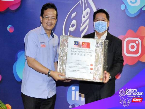 Pengarah Othree Management Sdn. Bhd, Kenneth Chen (kanan) menyampaikan sumbangan penutup hidung kepada Pengurus Hal Ehwal Agama Dan Penerbitan, Kumpulan Media Karangkraf Sdn. Bhd, Ahmad Yani Abd Manaf. - Foto ROSLI TALIB. 