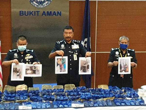 Ramli (tengah) menunjukkan dadah dan barangan yang dirampas.