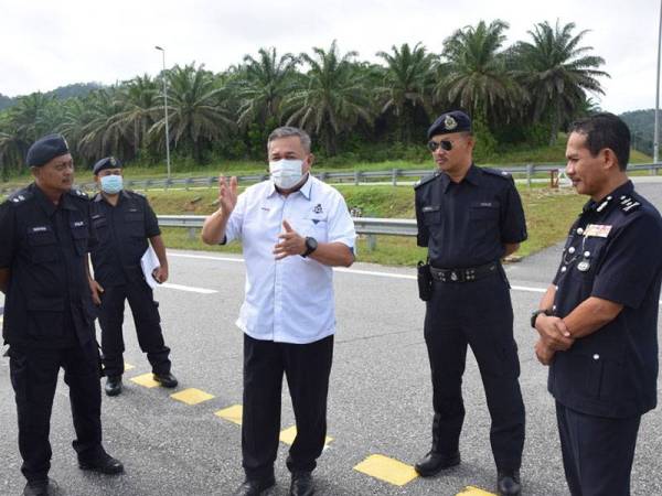 Roslee (tiga dari kanan) berbincang dengan Hanyan (kiri) dan pegawai-pegawainya di lokasi semasa turun padang melawat tapak sekatan jalan raya di kawasan R&R Perasing hari ini.