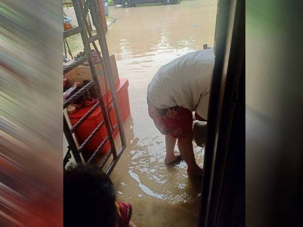 Penduduk mengemaskan barang selepas berlaku banjir.