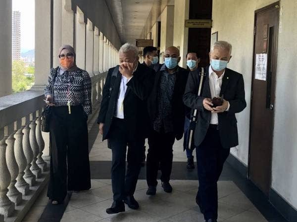 Bung Moktar (dua dari kiri) dan Zizie Ezette (kiri) beredar dari Mahkamah Sesyen Kuala Lumpur selepas perbicaraan ditangguh hari ini.