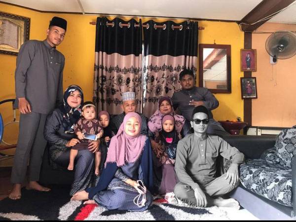 Arwah (bercermin mata) bersama keluarganya semasa Hari Raya tahun lepas di kediaman mereka.
