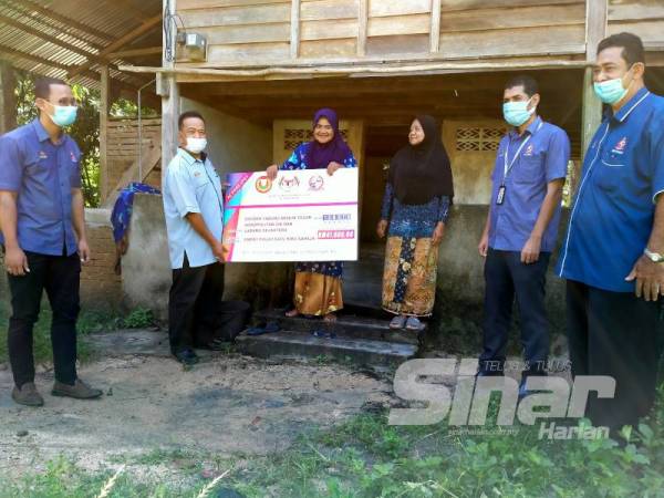 Noreha (tiga dari kiri) gembira menerima dividen daripada KEDA yang disampaikan oleh Ahmad Shukri.