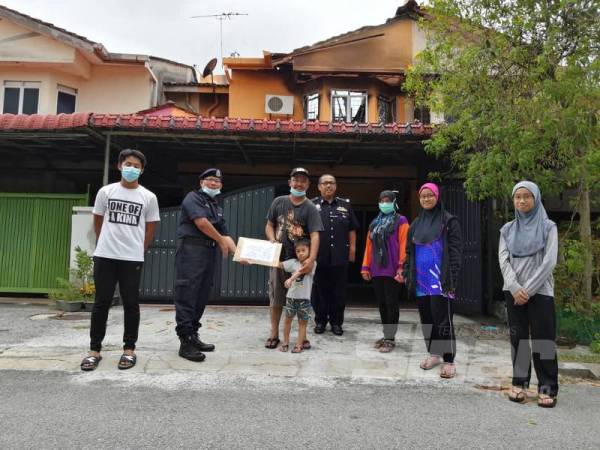 Mohamad Nordin menyerahkan sumbangan mewakili IPD Ipoh kepada Zulhamali.