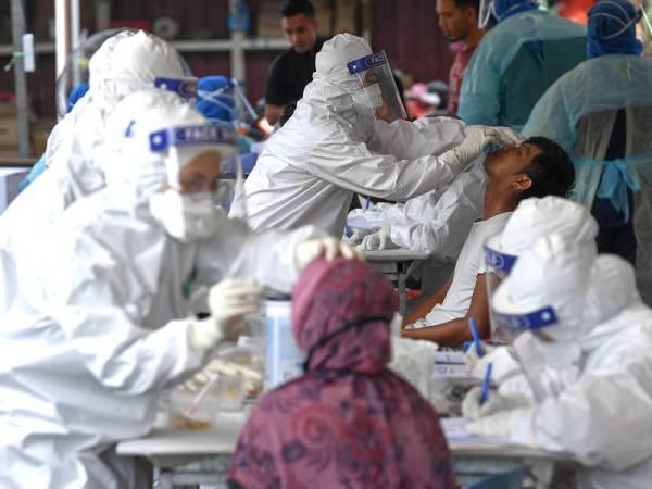 Petugas kesihatan menjalankan saringan Covid-19 terhadap peniaga Pasar Borong Gong Pauh ketika tinjauan hari ini. - Foto Bernama