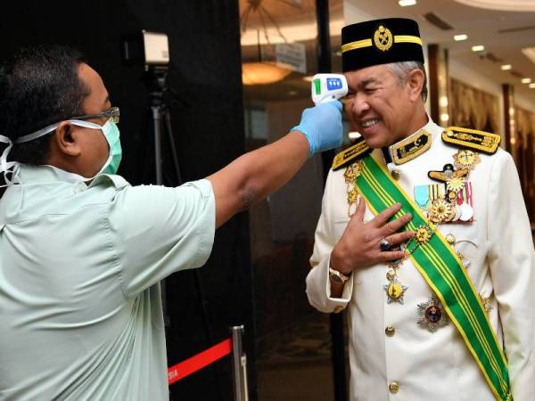 Ahli Parlimen Bagan Datuk, Datuk Seri Dr Ahmad Zahid Hamidi menjalani pemeriksaan suhu badan sebelum memasuki dewan pada Istiadat Pembukaan Mesyuarat Penggal Ketiga Parlimen ke-14 di Bangunan Parlimen hari ini. - Foto Bernama
