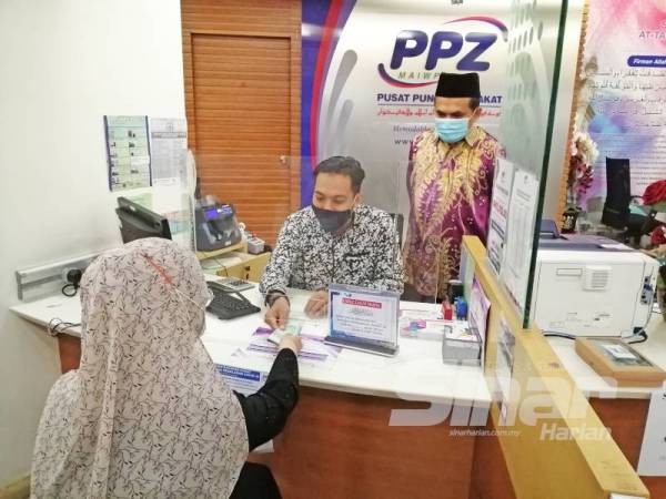 Ahmad Shukri (kanan) meninjau kaunter pembayaran zakat di PPZ-MAIWP Taman Shamelin.