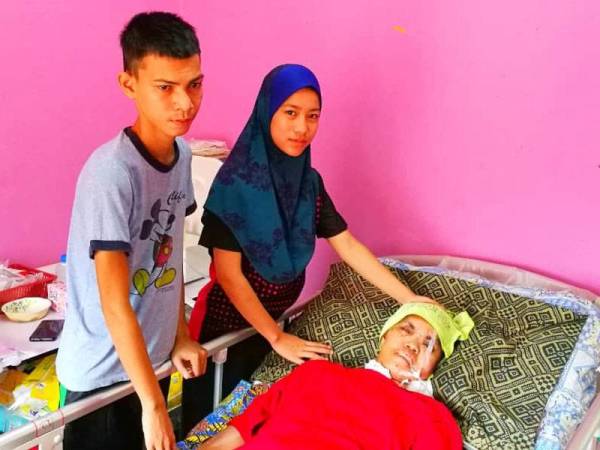 Nik Siti Aliza (berdiri, kanan) terpaksa melupakan hasrat menyambung pengajian demi menjaga ibunya yang koma dan abangnya, Nik Zulfakar (kiri) yang hilang ingatan akibat kemalangan langgar lari.