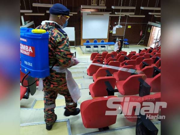 Anggota bomba menjalankan aktiviti nyah kuman di dewan sebuah IPT di Ipoh.