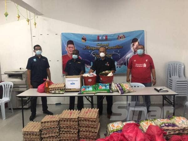 Mokhtar (tiga dari kiri) menyerahkan sumbangan kepada Maran di Pejabat Penyelaras DUN Rantau semalam.