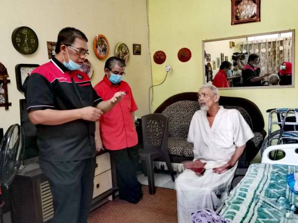 Baharudin (kiri) memberi kata-kata semangat kepada Amran sambil diperhatikan Supyan.