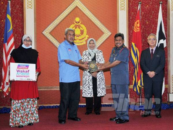 Hashim (dua dari kiri) menyampaikan sumbangan al-Quran kepada Abdul Wahab (dua dari kanan) sambil disaksikan Zuraida di Ibu Pejabat JBPM di sini hari ini. - Foto ROSLI TALIB