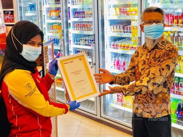 Nur Yasmin menerima sijil penghargaan dari Shairan (kanan).