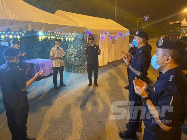Mat Kasim (tengah) mengaminkan doa ketika lawatannya di sekatan jalan raya Plaza Tol Simpang Ampat malam tadi.