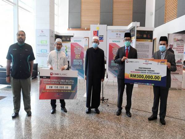 Zulkifli (tengah) bergambar kenangan pada Majlis Penyerahan Sumbangan Peruntukan Program Yadim Peduli: Musa'adah Covid-19 di Kompleks Islam hari ini. - Foto Bernama