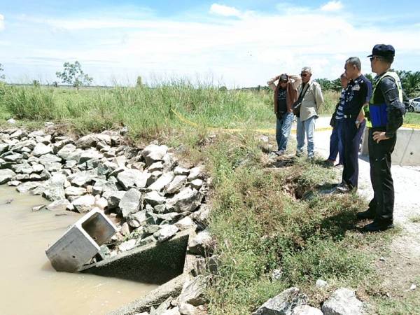 Barudin (dua dari kanan) turun ke lokasi kejadian bagi melihat operasi mencari dan menyelamat mangsa lemas di terusan Felcra Kampung Gajah, hari ini. - Foto PDRM Perak Tengah 