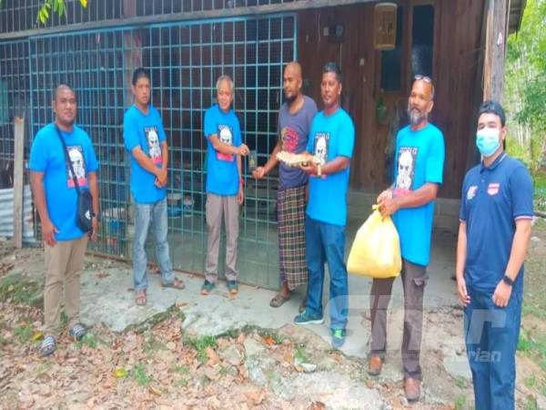 Muhammad Nasir (tiga dari kiri) menyampaikan sumbangan daripada Gu Sinar kepada penerima di Semerak.