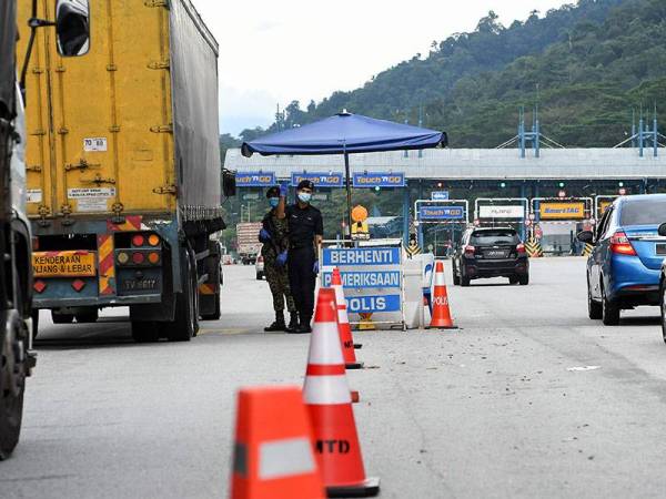 Anggota Polis dan Tentera mengawal aliran trafik di Plaza Tol Gombak menghala ke Pantai Timur ekoran sekatan jalan raya hari ini. - Foto: Bernama