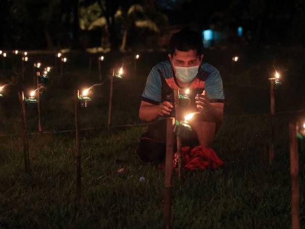 Penduduk Mohd Fitri Mokhtar menyalakan satu daripada 200 pelita bagi menghasilkan frasa 'Raya KL Je' ketika tinjauan foto Bernama di Kuarters Jabatan Kerja Raya (JKR) Sungai Besi hari ini.