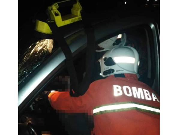 Anggota bomba dari Balai Bomba dan Penyelamat Mentakab membantu mengeluarkan dua mangsa yang tersepit. - Foto JBPM