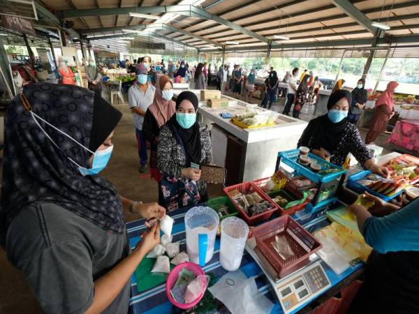 Kelihatan orang ramai terus mengamalkan norma baharu dengan penjarakan sosial semasa beratur serta memakai penutup hidung dan mulut ketika membeli santan dalam Perintah Kawalan Pergerakan Bersyarat (PKPB) semasa tinjauan di Pasar Hutan Kampung di sini hari ini. - Foto Bernama
