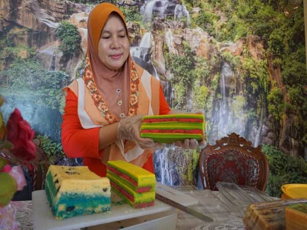Rajemah Rose Awi menunjukkan kek lapis masam manis yang ditempah pelanggan. - Foto Bernama 