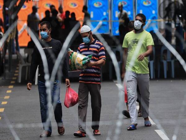 Sebahagian penghuni dilihat membawa barangan keperluan yang diedarkan ketika tinjauan di kawasan kawalan diperketatkan secara pentadbiran di sekitar Pudu hari ini. - Foto Bernama