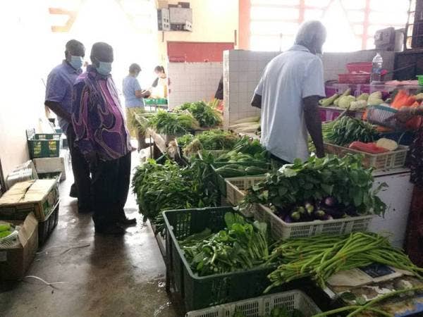 Vijayakumaran (kiri) meninjau sekitar pasar Rasah pagi tadi.