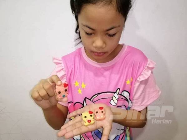 Anak keduanya, Nur Balqis Humayraa bersama biskut Hello Kitty yang dihasilkan.