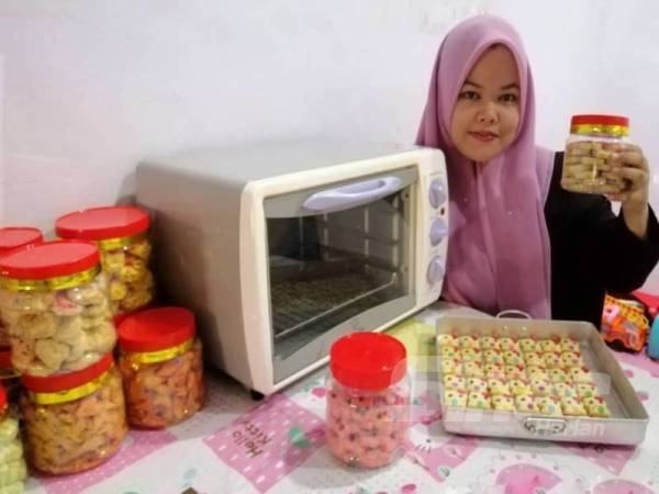 Nurul Farah Ayuni bersama oven kecilnya dan biskut raya Hello Kitty comel yang dihasilkan.