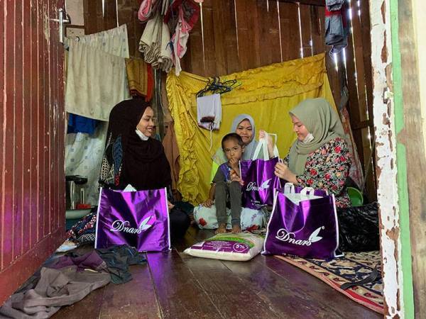 Irdina (kanan) menyampaikan sumbangan kepada Siti Fatimah di Kubang Kerian hari ini
