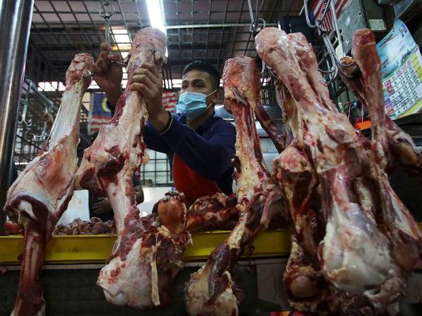 Peniaga, Shahrul Nidzma Mohd Shahari menggantung tulang lembu untuk dijual kepada orang ramai sempena hari mantai menjelang Ramadan di Pasar Ampangan hari ini. - Foto: Bernama