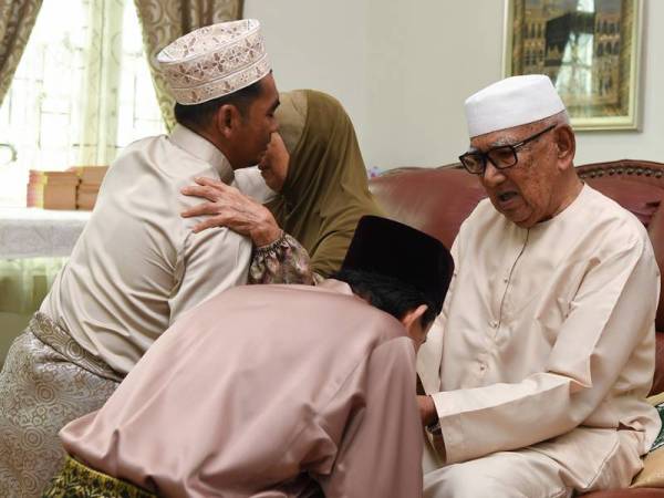 Baba Abd Rahman, 86, (kanan) dan isteri Rona Bachik, 84, bersalaman dengan cucu pada sambutan Aidilfitri dalam tempoh Perintah Kawalan Pergerakan Bersyarat (PKPB) ketika tinjauan di Kampung Bukit Besar, Kuala Terengganu semalam. Sambutan Aidilfitri dalam tempoh PKPB tetap meriah meskipun sebahagian anak, menantu, cucu serta cicitnya tidak dapat pulang bagi menyambut perayaan tersebut. - Foto Bernama