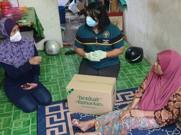 Dr Sara Chinnasamy (tengah) mewakili PKSP menyerahkan sumbangan Aidilfitri kepada salah seorang ibu tunggal yang memerlukan di Rantau Panjang, Selangor hari ini.