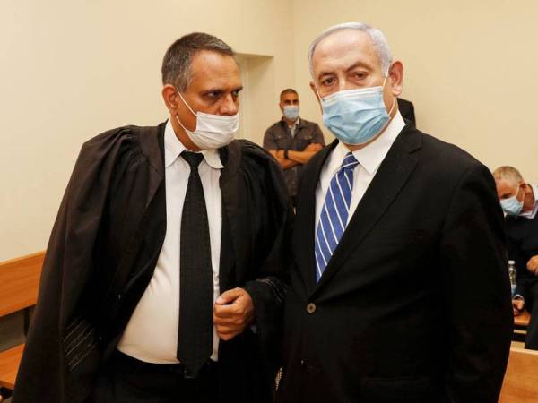 Netanyahu (kanan) tiba di mahkamah daerah di Baitulmaqdis pada hari pertama perbicaraan beliau semalam.