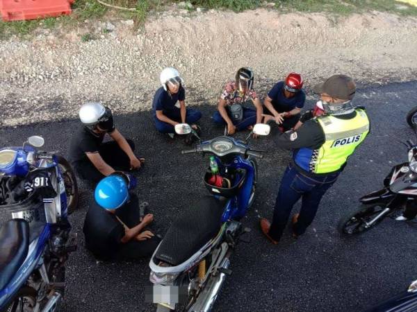 Anggota bertugas sedang melakukan pemeriksaan ke atas lima individu ini yang ditahan dipercayai hendak merempit. - Foto ihsan Facebook IPD Kemaman