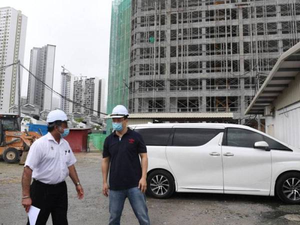 Jagdeep (kiri) diberi penerangan oleh kontraktor ketika membuat lawatan di tapak pembinaan Imperial Grande, Relau pagi tadi.