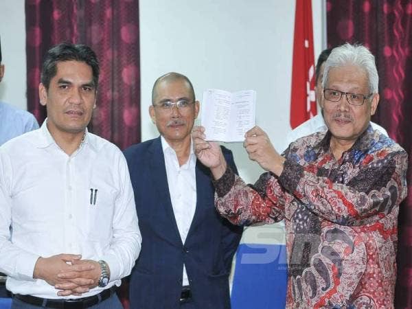 Hamzah menunjukkan buku perlembagaan parti Bersatu selepas mengadakan sidang media yang diadakan di Menara Yayasan Selangor. - Foto: ROSLI TALIB