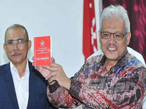 Hamzah menunjukkan buku perlambangaan parti Bersatu selepas mengadakan sidang media yang diadakan di Menara Yayasan Selangor. - Foto:ROSLI TALIB