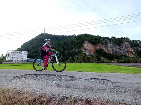 Hasdiana Othman berbasikal secara solo sekitar Gunung Keriang ketika melakukan aktiviti sukan luar semasa tinjauan foto Bernama hari ini.